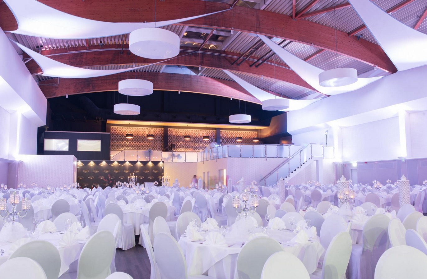 Hochzeitssaal Eventlocation Atrium – festlich dekoriert mit Bühne und Beleuchtung
